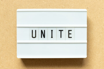 Lightbox with word unite on wood background
