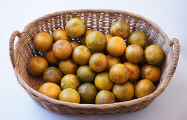 Organic orange fruits in rattan basket on white background. Seasonal Thai fruit in Nan Province, Thailand named 