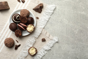 Fototapeta na wymiar Many different delicious chocolate truffles on light table, top view. Space for text