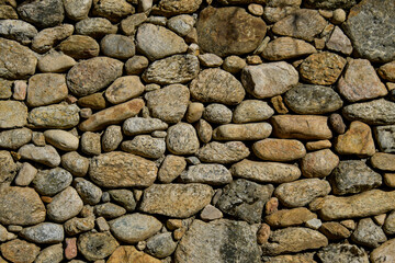 Stone wall with brown boulders.