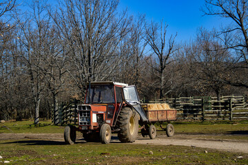 old red farm tractor with trailer.