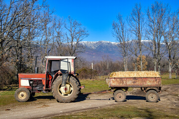 old red farm tractor with trailer.