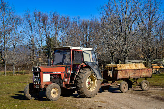 old red farm tractor with trailer.