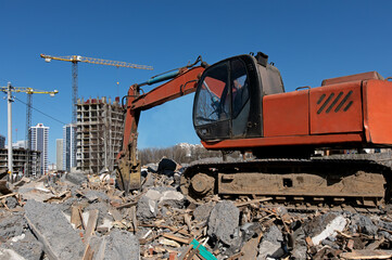 Construction Multi Storey Buildings. Working excavator digging at construction site during demolition and rebuilding houses