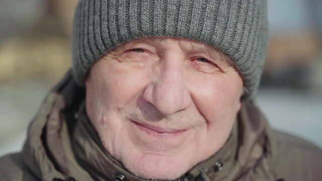 Caucasian white elderly man close up portrait on winter sunny day. Trekking active lifestyle male on retirement. Handheld video