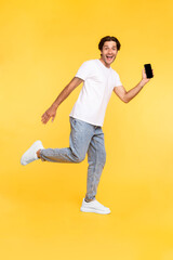 Naklejka premium Man showing white empty smartphone screen and jumping