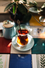 Tea in traditional glass on the table decorated with colorful ceramic tiles