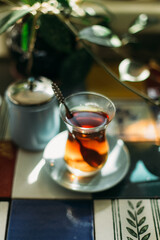 Turkish tea in traditional glass on the table decorated with colorful ceramic tiles