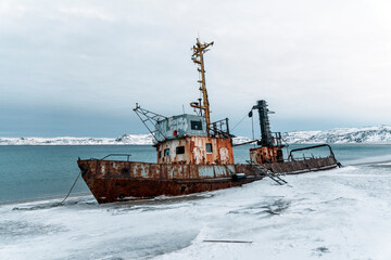 An old abandoned ship on the shore of the Barents Sea in the Arctic Ocean. The village of Teriberka...