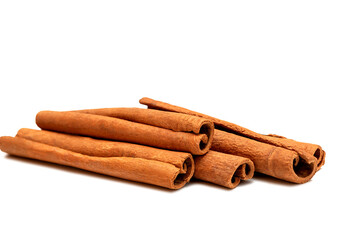 Heap of fragrant cinnamon sticks on white background