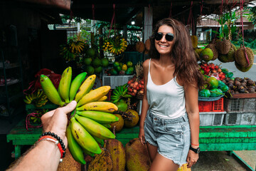 Beautiful woman on the background of a fruit shop in Indonesia, Bali. A beautiful girl at a...