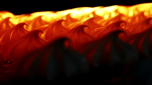 White marshmallows lit in orange in a drier machine. Manufacturing sweet desserts at present day factory. Close up. Blurred background.