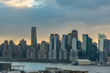 Vivid sunrise over Manhattan skyline with illuminated clouds above the buildings.