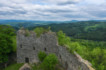 The ruins of an ancient castle on the Andelska mountain in Karlovy Vary (Czech Republic) on a sunny summer day. Medieval stone polygonal masonry walls. Panoramic view of scenic mountainous area 