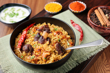 Mutton biryani Beef Biryani, Gosht or lamb biriyani Hyderabadi Dum biriyani with raita yoghurt dip special occasion Indian festival food Ramadan , Eid Hyderabad Kerala India Sri Lanka. Lankan food.