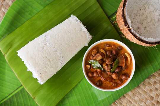 Popular South Indian breakfast puttu / pittu made of rice flour and coconut with banana and kadala curry, Kerala breakfast, India. Bamboo puttu prepared in steam 