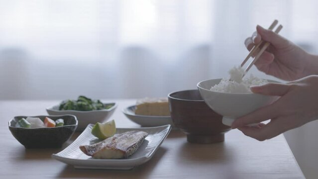 和食の朝ごはんを食べる女性の手元