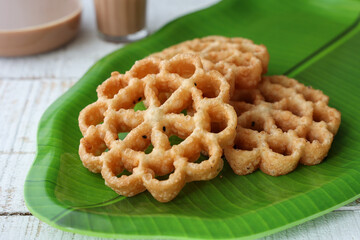 Achappam Rosette Cookie Indian milk masala tea traditional popular deep fried snack at tea time Kerala Tamil Nadu India Sri Lanka during festival christmas, Onam, Vishu. crunchy, sweet in flower shape
