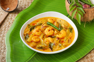Serving prawn mango curry Chemmeen Manga shrimp in coconut milk Spicy Kerala fish curry popular...