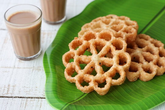 Achappam Rosette Cookie Indian milk masala tea traditional popular deep fried snack at tea time Kerala Tamil Nadu India Sri Lanka during festival christmas, Onam, Vishu. crunchy, sweet in flower shape