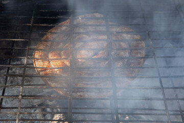South African lamb sausage, known as boerewors, being grilled over hot coals, as part of a traditional South African cooking tradition called "braai".