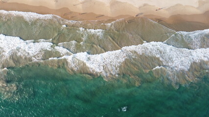 Fototapeta na wymiar Aerial view of an emerald green sea and big foaming waves. Indian Ocean. Dikwella beach. Sri Lanka