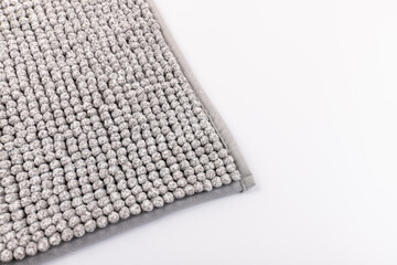 Soft grey bath mat against white background, closeup.Bath Accessories. Top view.