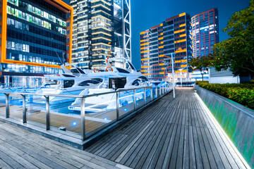 Fototapeta premium On the waterfront square platform and yacht ship in the urban business district