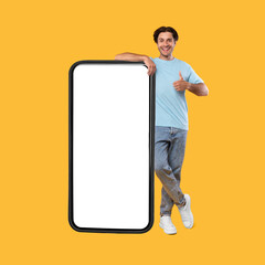 Happy man showing white empty smartphone screen and thumbs up