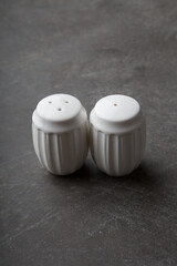 Salt and pepper shakers served on a black background
