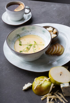 Bowl of fresh cream soup with croutons and pears