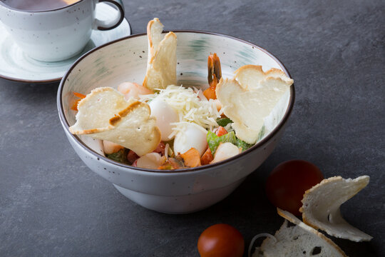 Bowl of shrimp caesar salad served for lunch in a cafe