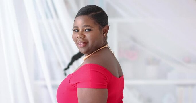 happy young african american woman with long hair braid whirling around on white cloth background