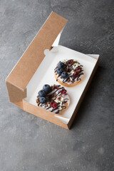 Box of fresh donuts to go on a black table