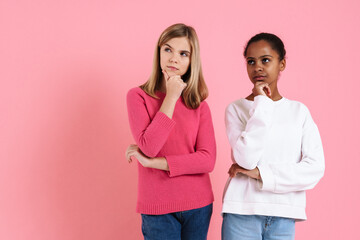 Multiracial puzzled girls posing and looking aside