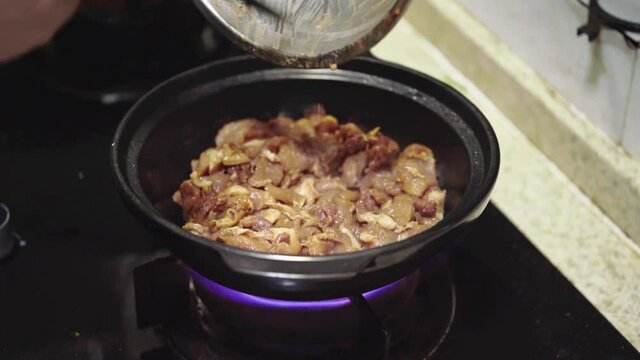 A Chinese Cantonese chef is making traditional Cantonese food, pork in claypot