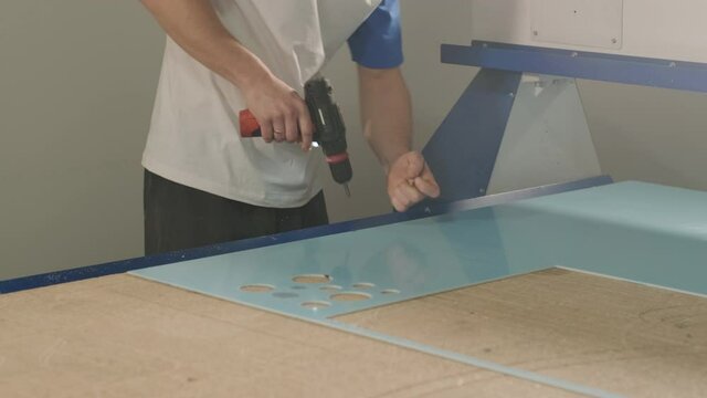 Production of advertising signs in the factory. Screwdriver tightens the screw