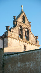 Fototapeta na wymiar Campanario de iglesia medieval tras muro de piedra