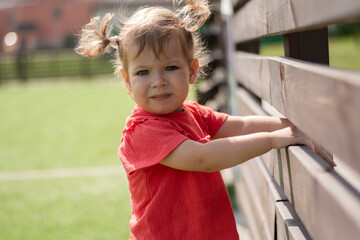 Serious little child on the street looking straight into the frame.