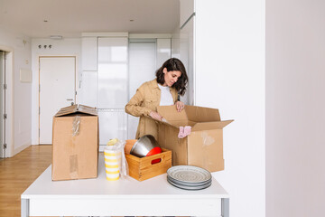 Woman unpacking carton box on floor