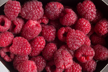Close up of the organic texture of a group of raspberries piled up. Fruits of the forest.