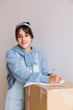 Young woman signing rent contract during relocation