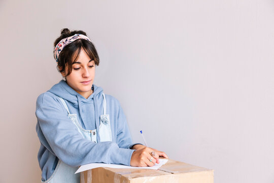 Young woman signing rent contract during relocation