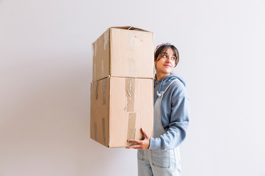 Positive woman carrying carton boxes