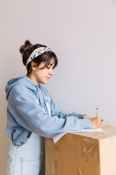 Young woman signing rent contract during relocation