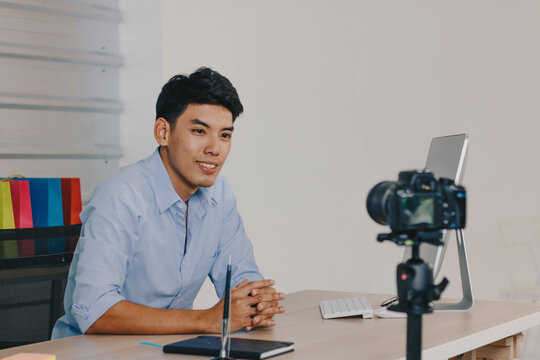 A young attractive Asian man is recoding footage for online contents.