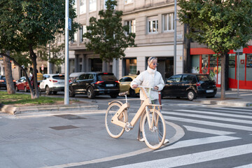 Female cyclist walking near crosswalk