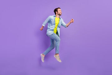 Fototapeta na wymiar Full size profile side man running fast speed jumping carefree weekend day isolated on purple color background