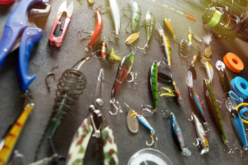 Fishing tackle - fishing spinning rod, hooks and lures on gray background. Active hobby recreation...