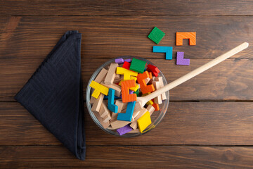 Creative idea concept - wooden puzzle in bowl with spoon. Develop new idea, food for inspiration.